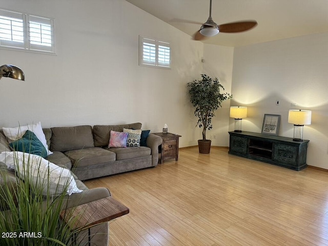 living room featuring a ceiling fan and light wood-type flooring