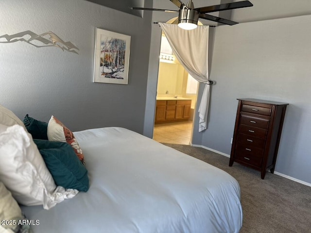 bedroom with light colored carpet, connected bathroom, baseboards, and a ceiling fan