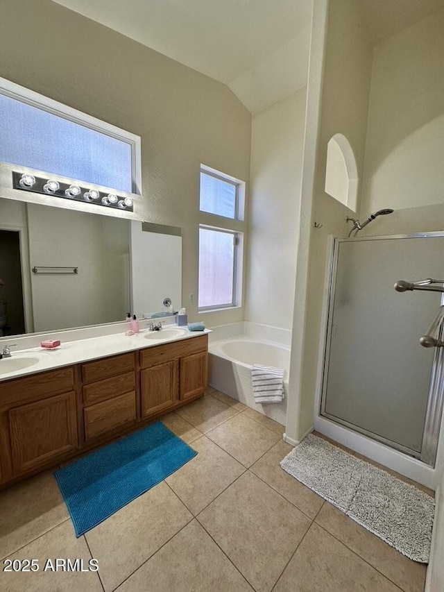 full bath featuring a stall shower, tile patterned flooring, double vanity, a bath, and lofted ceiling