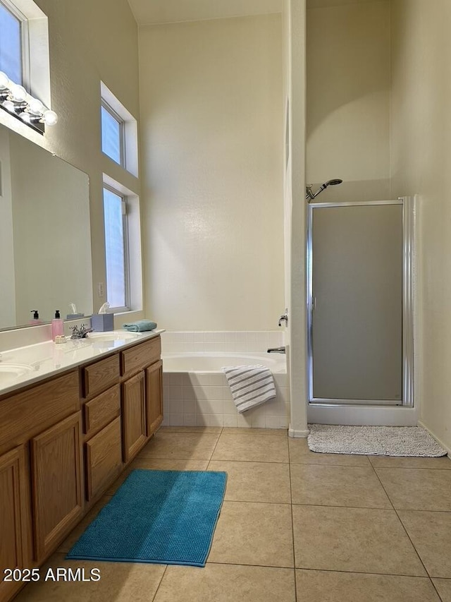 bathroom with a garden tub, a shower stall, tile patterned flooring, and double vanity