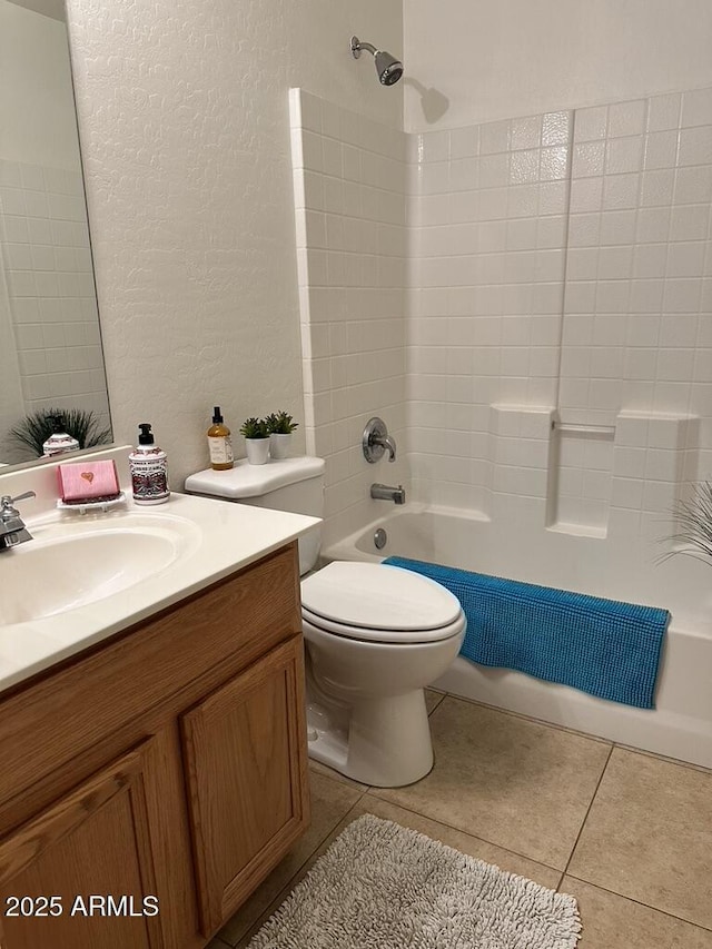 bathroom featuring a textured wall, vanity, toilet, tub / shower combination, and tile patterned floors