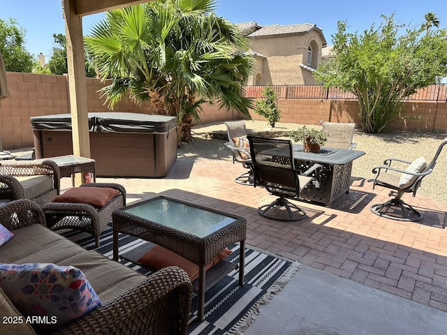 view of patio featuring a hot tub, a fenced backyard, and outdoor dining area