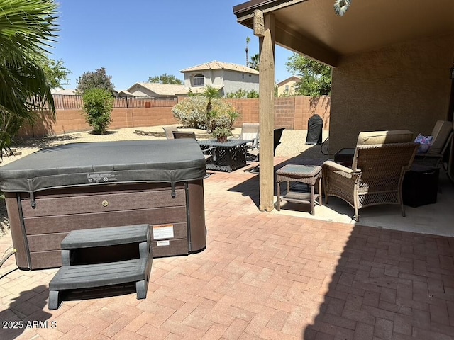 view of patio featuring a hot tub and a fenced backyard