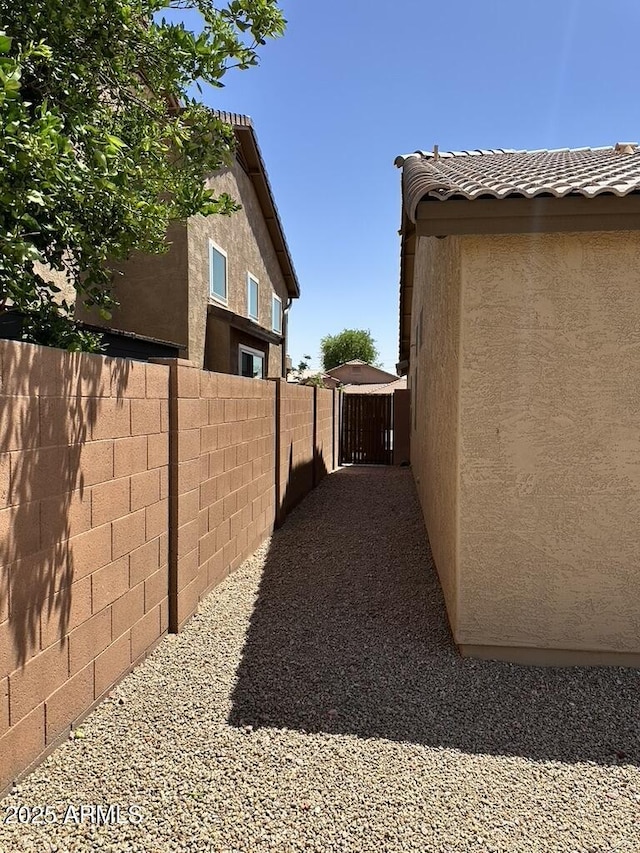 view of property exterior with stucco siding and fence