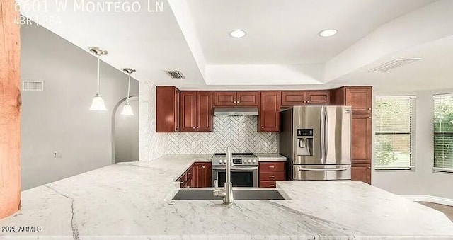 6601 W Montego Ln, Glendale, AZ 85306 - kitchen with stainless steel appliances, a peninsula, under cabinet range hood, backsplash, and a tray ceiling