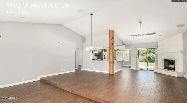 6601 W Montego Ln, Glendale, AZ 85306 - unfurnished living room featuring vaulted ceiling, a ceiling fan, a fireplace with raised hearth, dark wood-type flooring, and baseboards