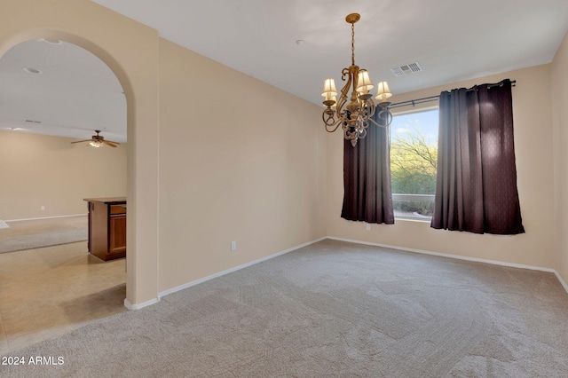 unfurnished room with ceiling fan with notable chandelier and light colored carpet