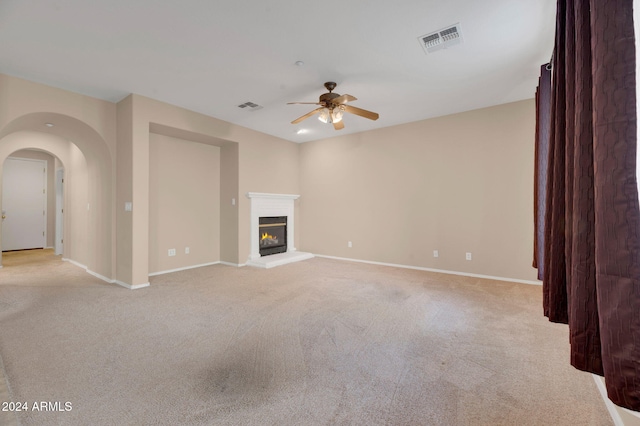 unfurnished living room featuring ceiling fan and light colored carpet