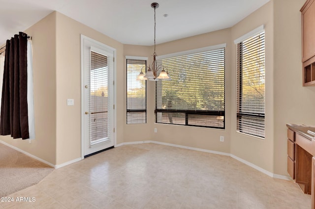 unfurnished dining area with a chandelier