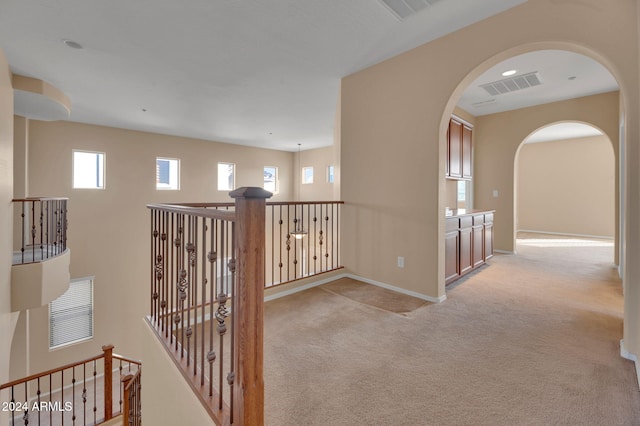 corridor featuring light colored carpet