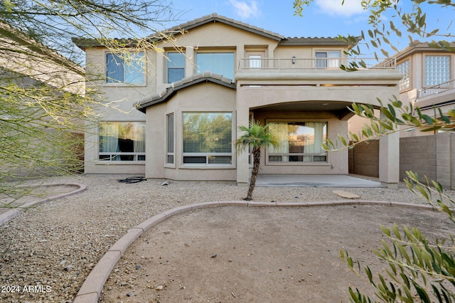 rear view of property featuring a balcony and a patio area