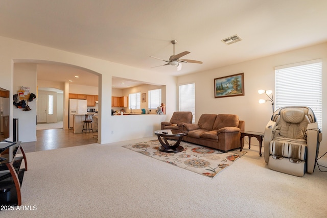 170 E Canary Ct, San Tan Valley, AZ 85143 - living room featuring a ceiling fan, light carpet, and arched walkways