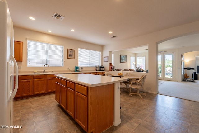 170 E Canary Ct, San Tan Valley, AZ 85143 - kitchen featuring a sink, open floor plan, light countertops, arched walkways, and white fridge with ice dispenser