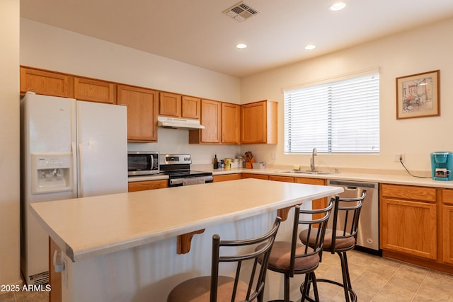 170 E Canary Ct, San Tan Valley, AZ 85143 - kitchen with stainless steel appliances, under cabinet range hood, a sink, a kitchen breakfast bar, and a center island