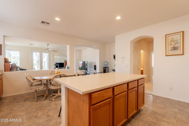 170 E Canary Ct, San Tan Valley, AZ 85143 - kitchen with arched walkways, a center island, light countertops, open floor plan, and recessed lighting