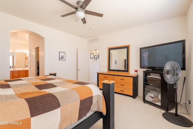 170 E Canary Ct, San Tan Valley, AZ 85143 - bedroom with arched walkways, light carpet, ceiling fan, and ensuite bath