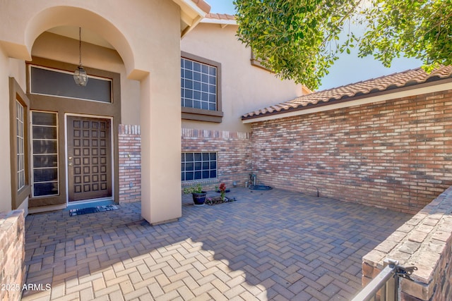 view of exterior entry featuring a patio area