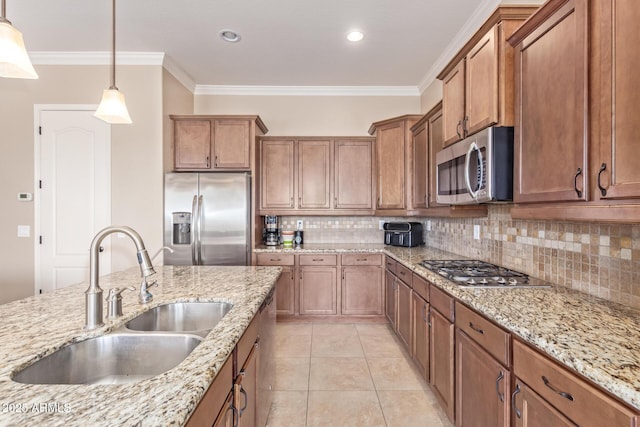 kitchen with ornamental molding, a sink, appliances with stainless steel finishes, brown cabinetry, and light tile patterned floors