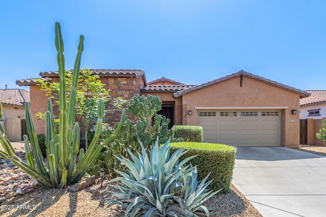 view of front of home featuring stucco siding, concrete driveway, an attached garage, and a tiled roof