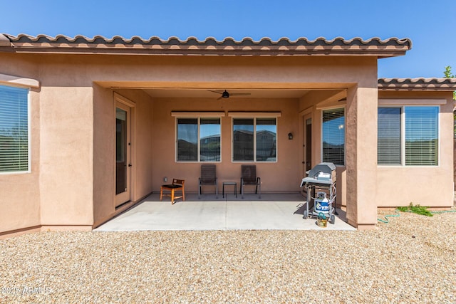 back of house featuring stucco siding, a ceiling fan, and a patio