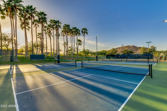 view of sport court with fence and a mountain view