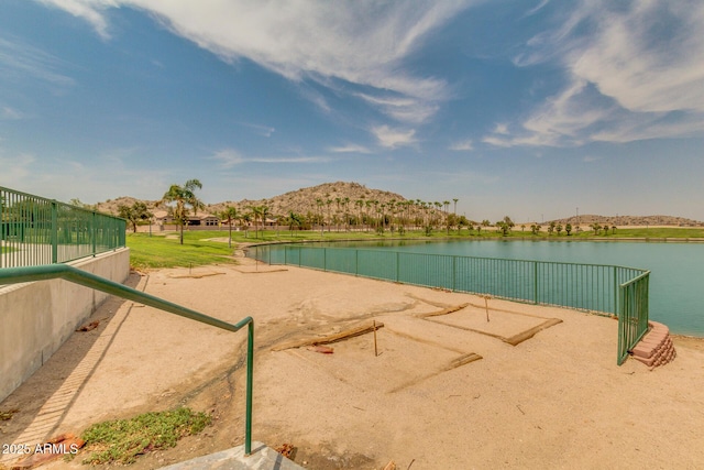 view of property's community featuring fence and a water view