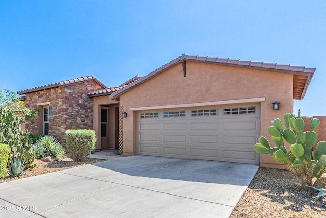 view of front facade with stucco siding, driveway, stone siding, an attached garage, and a tiled roof