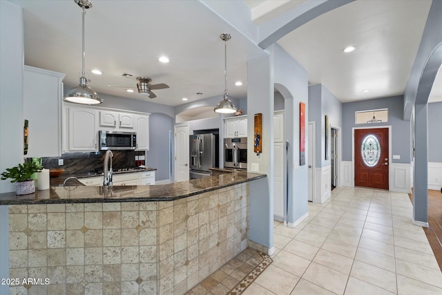 34611 N Sunset Trl, Cave Creek, AZ 85331 - kitchen with appliances with stainless steel finishes, ceiling fan, a peninsula, arched walkways, and white cabinetry