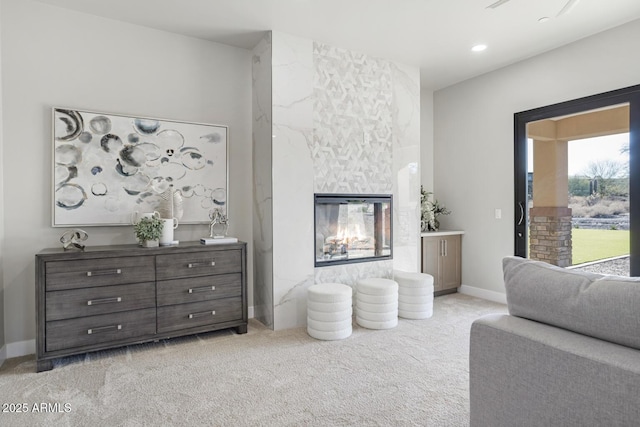 living room featuring a premium fireplace and light carpet