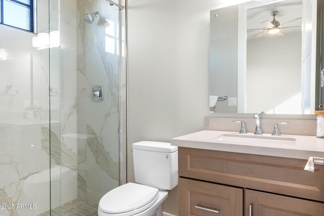 bathroom featuring vanity, ceiling fan, a shower with door, and toilet