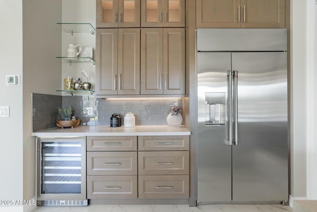 kitchen with stainless steel built in fridge, beverage cooler, and backsplash