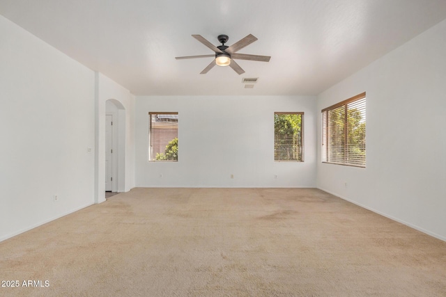 13599 W Monte Vista Rd, Goodyear, AZ 85395 - unfurnished room featuring arched walkways, ceiling fan, light carpet, and baseboards