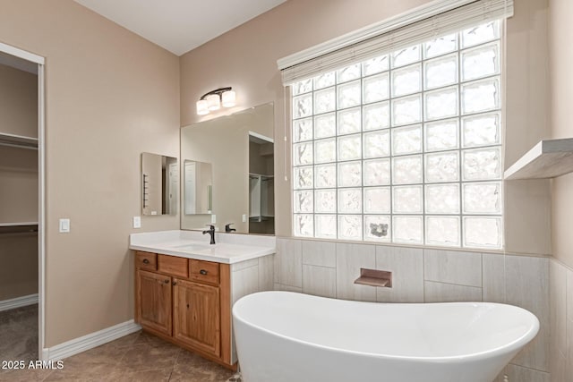 6805 S Sapphire Way, Chandler, AZ 85249 - full bath with plenty of natural light, a freestanding tub, vanity, a walk in closet, and tile walls