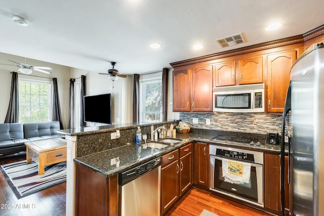 5734 S 21st Pl, Phoenix, AZ 85040 - kitchen with appliances with stainless steel finishes, open floor plan, ceiling fan, a peninsula, and light wood-type flooring