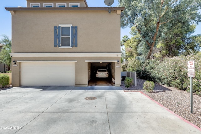 5734 S 21st Pl, Phoenix, AZ 85040 - view of front of property with stucco siding, a garage, and driveway
