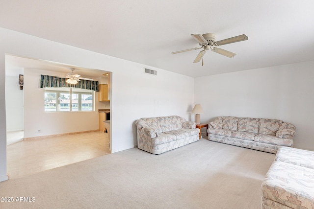 living room with visible vents, light carpet, baseboards, and ceiling fan