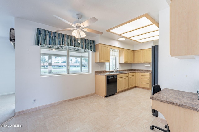 kitchen featuring baseboards, a skylight, a sink, light brown cabinetry, and black appliances