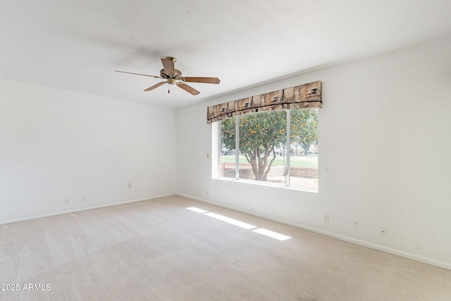 unfurnished room featuring a ceiling fan, baseboards, and light carpet