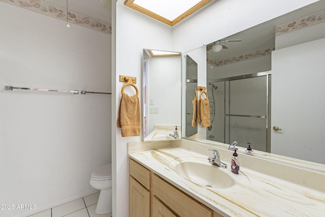 full bathroom with vanity, ceiling fan, a shower stall, tile patterned floors, and toilet