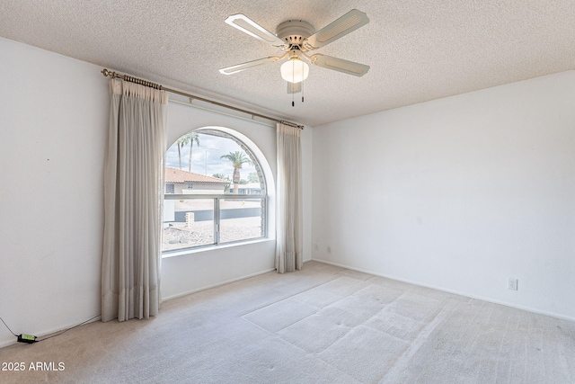 empty room with carpet flooring, a textured ceiling, and ceiling fan