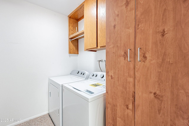 laundry room featuring cabinet space, baseboards, and washer and clothes dryer