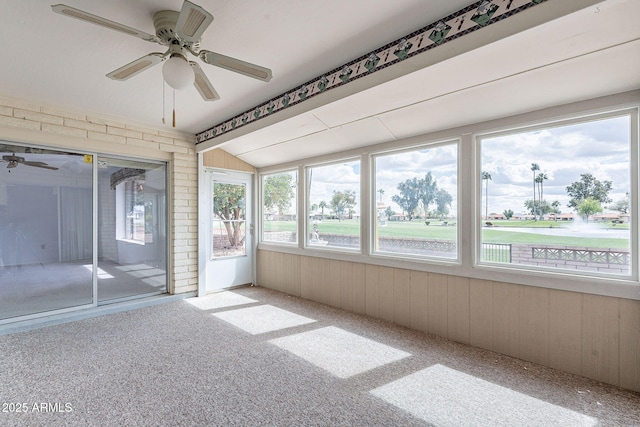 unfurnished sunroom with ceiling fan and vaulted ceiling