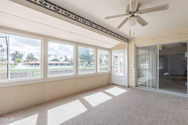 unfurnished sunroom with vaulted ceiling and a ceiling fan