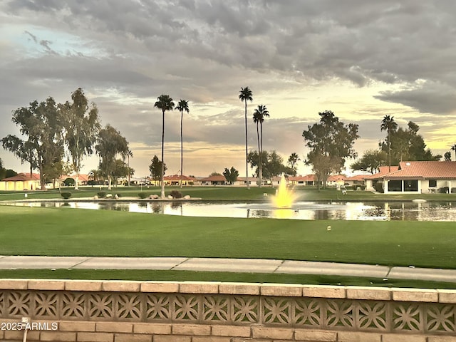 view of home's community with a yard and a water view