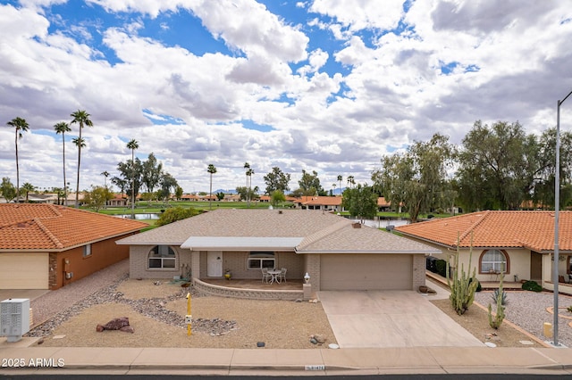 ranch-style house with concrete driveway, brick siding, a garage, and central AC