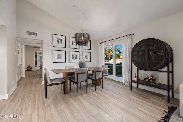 7821 N Via De La Sombre, Scottsdale, AZ 85258 - dining area featuring light wood finished floors, a chandelier, baseboards, and high vaulted ceiling