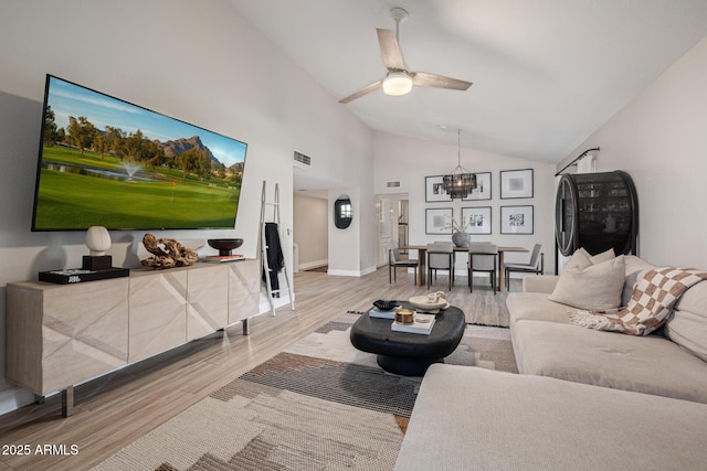 7821 N Via De La Sombre, Scottsdale, AZ 85258 - living room with light wood-style flooring, a ceiling fan, baseboards, high vaulted ceiling, and a chandelier