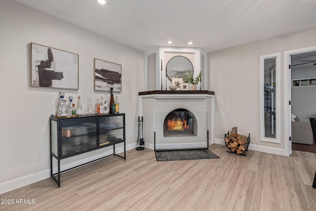 7821 N Via De La Sombre, Scottsdale, AZ 85258 - living room featuring wood finished floors, recessed lighting, a glass covered fireplace, and baseboards