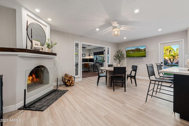 7821 N Via De La Sombre, Scottsdale, AZ 85258 - dining area featuring baseboards, a ceiling fan, a lit fireplace, recessed lighting, and light wood-style flooring