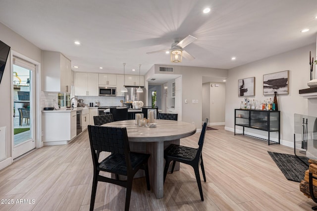 7821 N Via De La Sombre, Scottsdale, AZ 85258 - dining area with light wood-type flooring, baseboards, recessed lighting, ceiling fan, and a dry bar